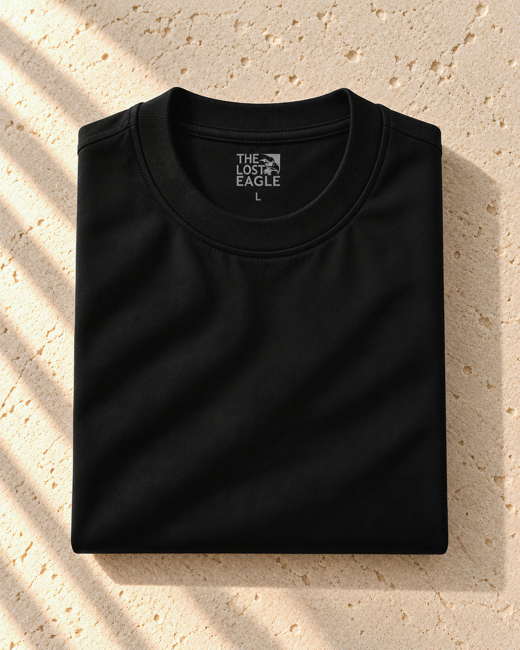 the signature tee in black, folded, printed neck label